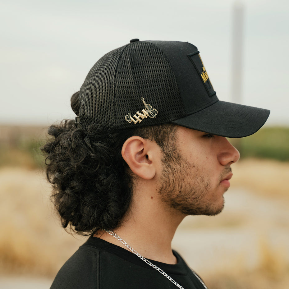 Pines, gorras y mercancía de Los Hermanos Mendoza